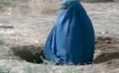 Barbaric: Video footage shows Siddqa, 25, covered completely by a blue burkha, buried up to her waist in the ground as a crowd of people watches on.